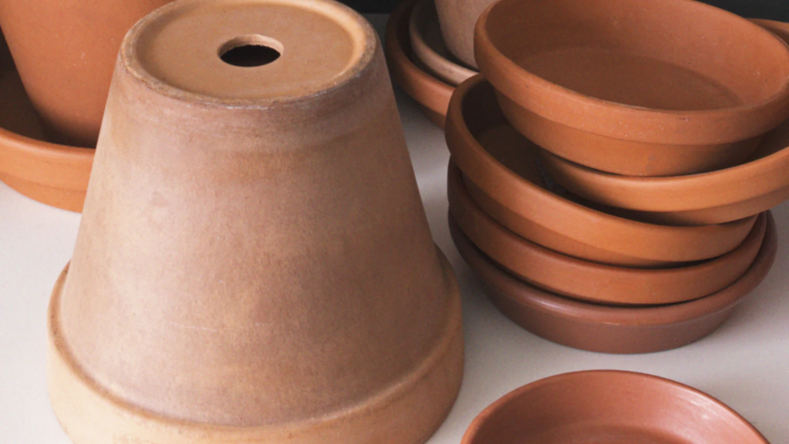 Unglazed terracotta pots and saucers stacked together